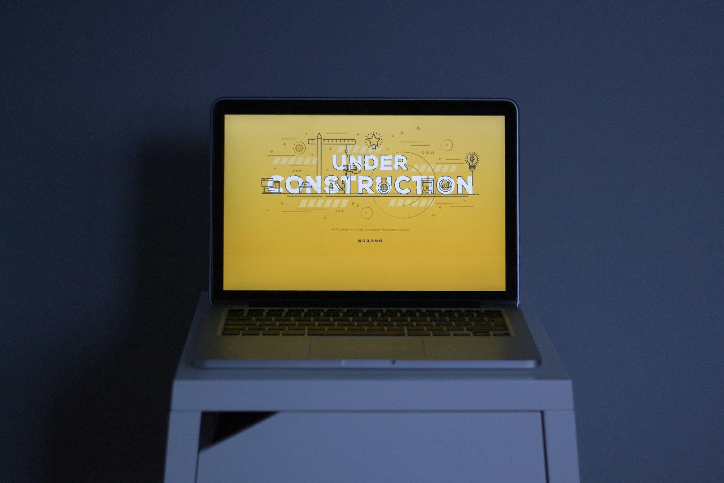 A laptop showing an under construction page while a new website is being built